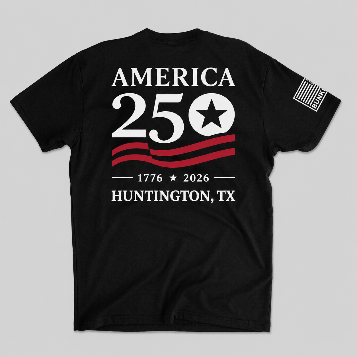 A black short-sleeve t-shirt shown flat against a light gray background, featuring a patriotic graphic on the back with the text 'AMERICA 250 1776 2026 HUNTINGTON, TX' in white and red, plus a small American flag print on the left sleeve.